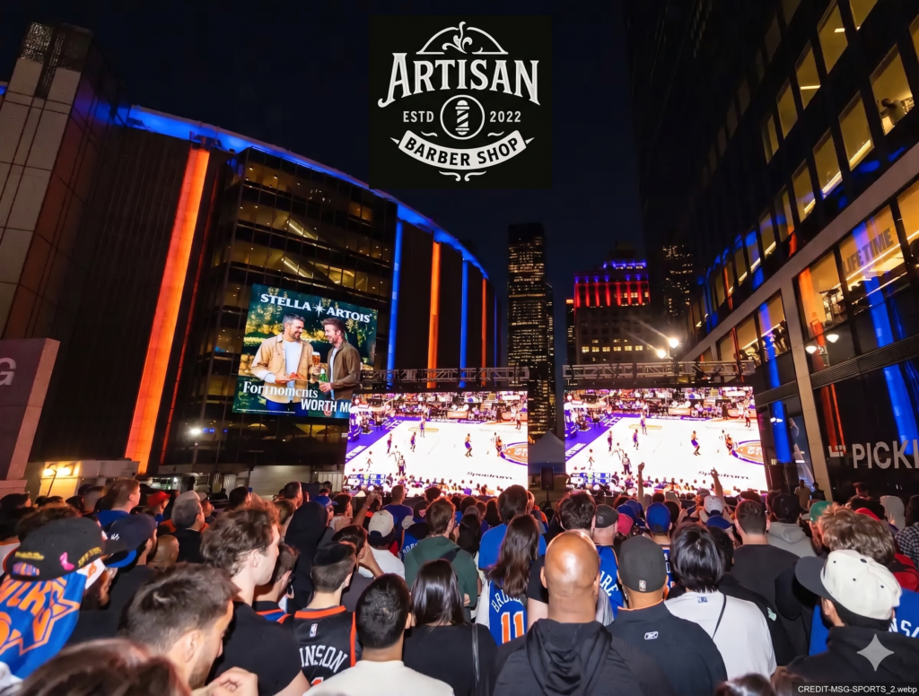 Exterior night view of Madison Square Garden with blue and orange lighting, a large crowd from behind.